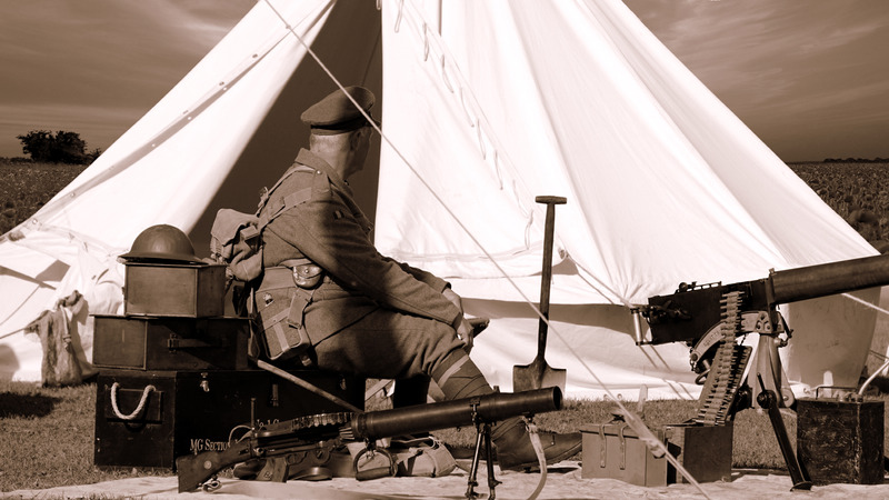 Canva - Sepia Photo of Man in Military Uniform Sitting Near Guns and White Gazebo (1)